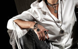 Adjustable bronze hematite bracelet worn on the wrist, featuring a sleek design and metallic finish, paired with layered accessories.