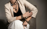 Bronze hematite bracelet with a weighty, metallic finish, worn stacked with layered jewelry.