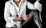 Adjustable bronze hematite bracelet worn stacked with bracelets on a wrist, paired with a white shirt and metallic leggings.