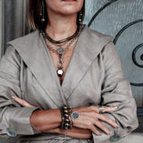 Hematite bracelet in bronze tones worn stacked with other bracelets on a model's wrist, showcasing a casual, edgy style.