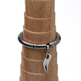 Edgy chic gemstone bracelet in silver hematite, featuring a tooth charm; elastic and stretchy for a layered look.