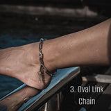 Silver oval link chain anklet worn on the ankle, showcasing a sleek, minimal design with a polished finish.