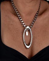 Chunky stainless steel box chain necklace with oversized silver-plated carabiner clasp, worn as a stylish choker.