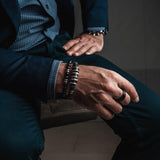 Men’s bracelet showcasing bold silver-plated and dark leather accents, worn alongside other statement style bracelets.