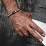 Labradorite beaded bracelet featuring a mix of gray and black stones, worn on a man's wrist alongside a silver ring.