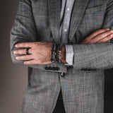 Men's labradorite beaded bracelet sits alongside leather bracelets, showcasing iridescent beads styled with a grey blazer.