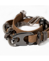 Brown leather bracelet with metal chain and clasp on a white background