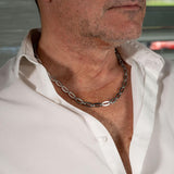 Casual stainless steel choker necklace worn by a man, featuring oval links and dark silver finish.