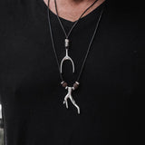 Men's layered adjustable black cord necklace featuring a metal wishbone pendant and brown lava stone accents.