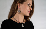 Contemporary statement earrings featuring a circular design with an ancient Greek coin pendant.