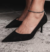 Silver anklet with faceted cut glass beads in "silver night" color, worn on ankle with black high-heeled shoes.