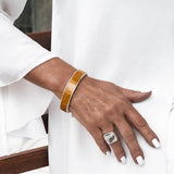 Yellow leather wrap bracelet featuring a reptile texture and bold buckle, paired with a silver antique plated bangle.