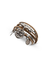 Tan suede bracelet featuring four strands, silver-plated beads, and antique coin charms for a boho look.