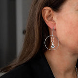 Elegant loop earrings in silver tone with Austrian crystal pendant, enhanced by a sleek dangle design.