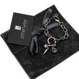 Rock style silver bracelet featuring a grey Swarovski crystal, shackle pendant, and teardrop bar, set on a stainless-steel chain.