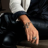 Rock-style silver bracelet featuring a Swarovski crystal charm and shackle pendant, worn on a model's wrist.