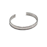 Silver-plated hammered bangle cuff with a minimal style, adjustable and ideal for stacking with other bracelets.