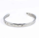 Silver-plated hammered metal bangle with a sleek minimal design, perfect for stacking with other bracelets.