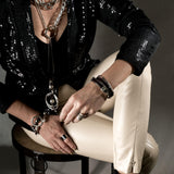 Silver-plated hammered bangle worn stacked with leather and other bracelets, showcased on a model's wrist.
