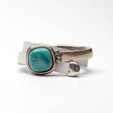 Chunky white leather wrap bracelet featuring a turquoise resin stone and a half metal cuff with a hinge.