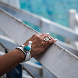 White leather wrap bracelet featuring a large turquoise resin stone and a metal cuff, styled around a wrist with a silver ring.
