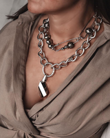 Chunky sterling silver plated chain necklace with a champagne crystal pendant, worn with a casual top.