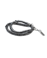A multi-strand beaded bracelet featuring metallic gunmetal gray and silver beads, with a silver chain extender and a rectangular brand tag engraved with 'SARAH BURTON'.