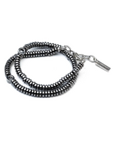 A multi-strand beaded bracelet featuring dark gunmetal gray metallic beads and silver-toned chain details with a rectangular brand tag, set against a plain white background.