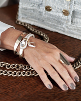 Rose gold cuff bangle worn stacked with other bracelets, featuring a flexible design for adjustable fit.
