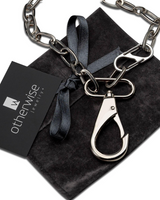 Silver chain necklace with clasp on a black velvet surface, accompanied by an Otherwise Jewelry card.