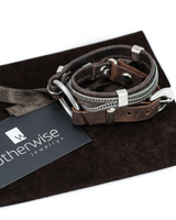 Dark brown stitched leather double wrap bracelet featuring iron chains and silver-plated accents, presented on a dark suede pouch.