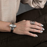 Chunky hammered silver-plated metal ring worn on a hand, showcasing a chic and edgy design.