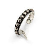 Antique silver bangle featuring black leather and silver stud chain, designed for a stacked look, adjustable fit.