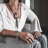 Antique silver bangle with black leather and silver stud chain, worn on the wrist with a casual outfit.