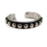 Antique silver bangle featuring a black leather band and silver stud chain, adjustable for a custom fit.