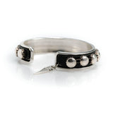 Antique silver bangle featuring black leather and silver studs, adjustable for a comfortable fit.