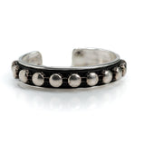 Antique silver bangle featuring a black leather band and silver stud chain, adjustable for a comfortable fit.