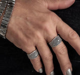 Adjustable silver plated ring featuring dark ethnic cone and dot designs, worn on the thumb and ring finger.