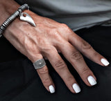Silver plated dark ethnic cone and dots adjustable ring worn on the pinky, paired with a silver bracelet.