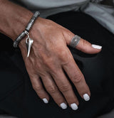 Adjustable silver-plated ring with dark ethnic cone and dot pattern, worn on thumb, alongside a chunky bracelet.