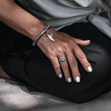 Adjustable silver plated ring featuring a dark ethnic cone design and dots, worn on the thumb.