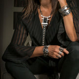 Adjustable silver-plated chunky rings worn together on a hand, styled with a black blouse and layered bracelets.