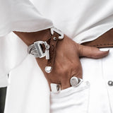 Bold snake chain bracelet with a brown woven leather band, featuring silver metal endings and an "Otherwise" logo tag.