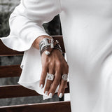 Bold snake chains bracelet featuring a warm brown woven leather band with stainless steel endings, worn on a model's wrist.