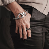 Adjustable Wavy Silver Ring on the index finger, featuring a flat wavy design, paired with a silver bracelet and black nails.