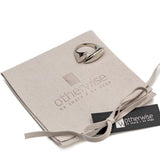 Adjustable wavy silver ring placed on a beige gift pouch with a logo, showcasing its unique flat wavy top design.
