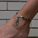 Chunky silver metal anklet featuring a fish pendant, worn on the ankle with a rhombus link chain.