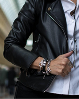 Silver-plated stackable bangle bracelet worn among multiple layered bracelets, showcasing its sleek metallic finish.
