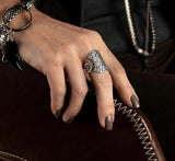 Boho rings set featuring a large oval ethnic calendar ring with intricate detailing, worn on a hand with neutral nail polish.