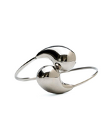 Elegant stainless steel cuff bracelet featuring large, polished drops, designed to be worn on the wrist or over sleeves.